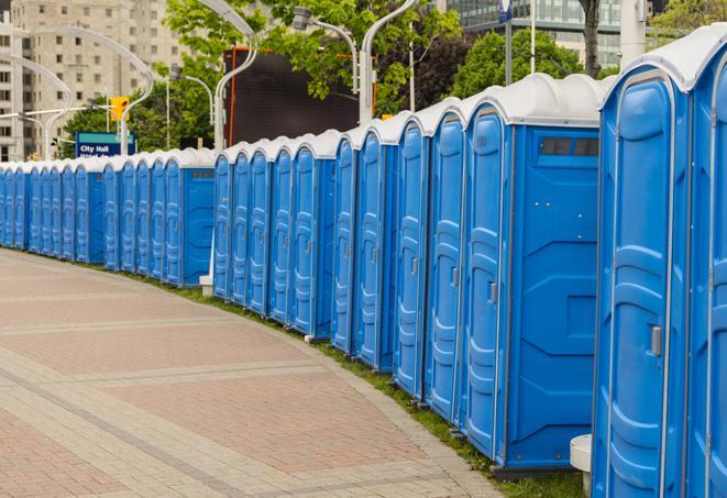 a row of portable restrooms at an outdoor special event, ready for use in Artesia